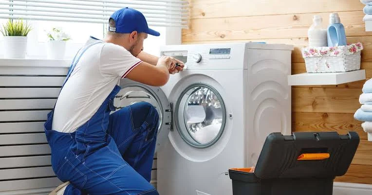 Service professional adjusting a front-loading washing machine